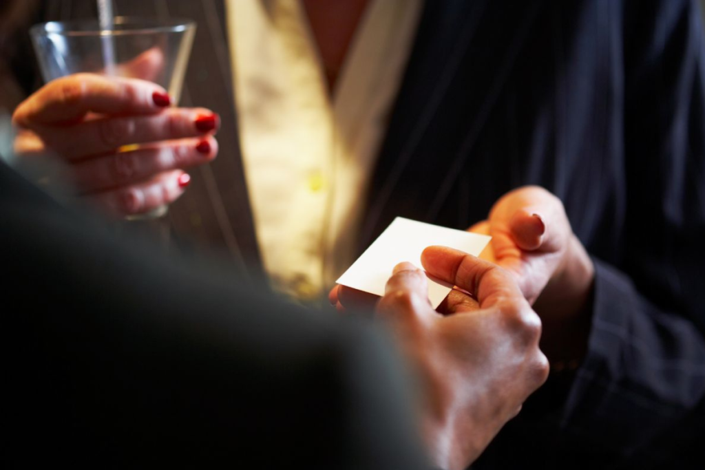 Handing out business cards at a networking event