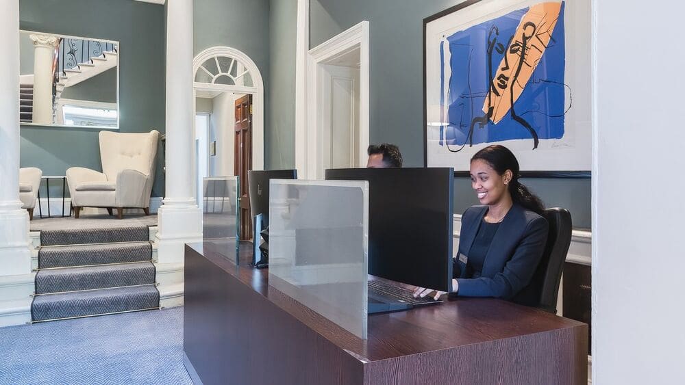 Team Members At Their Desks Smiling (1)