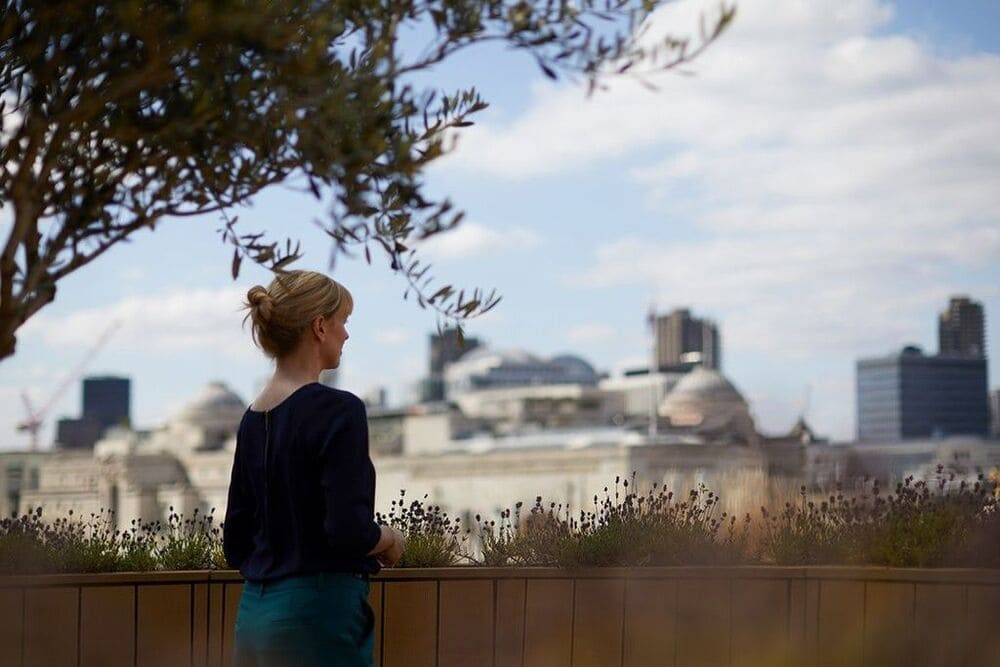 Woman Standing On Outdoor Terrace Spacing Overlooking London (1)