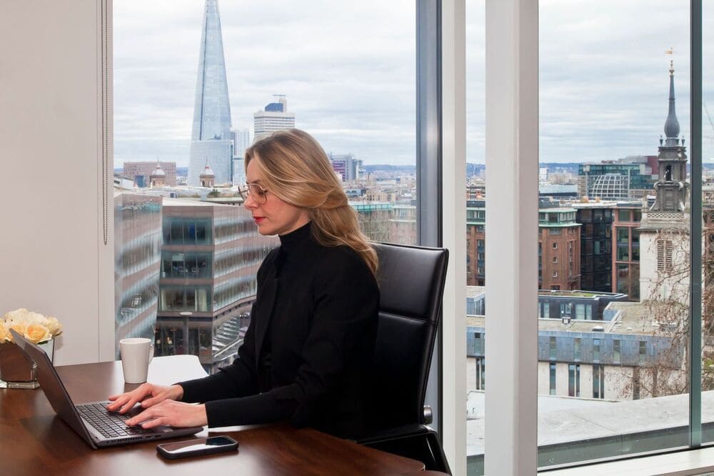 Woman Working In An Argyll Office With A View Of London Behind Her (1)